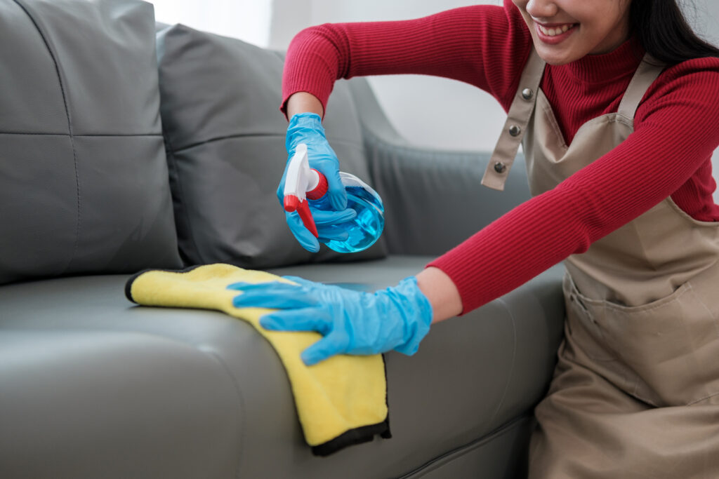 Professional cleaning service, housekeeping. Hygiene and cleanliness in the kitchen. Cleaning lady with gloves wipes dust from furniture with a cloth